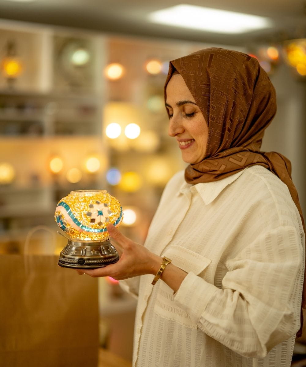 Woman holding a decorative lamp in an indoor setting