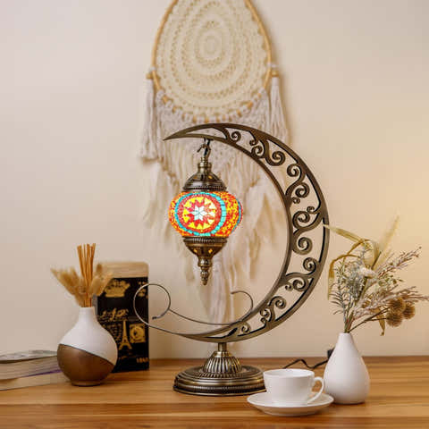 Decorative moon lamp on a crescent moon stand with a dreamcatcher in the background