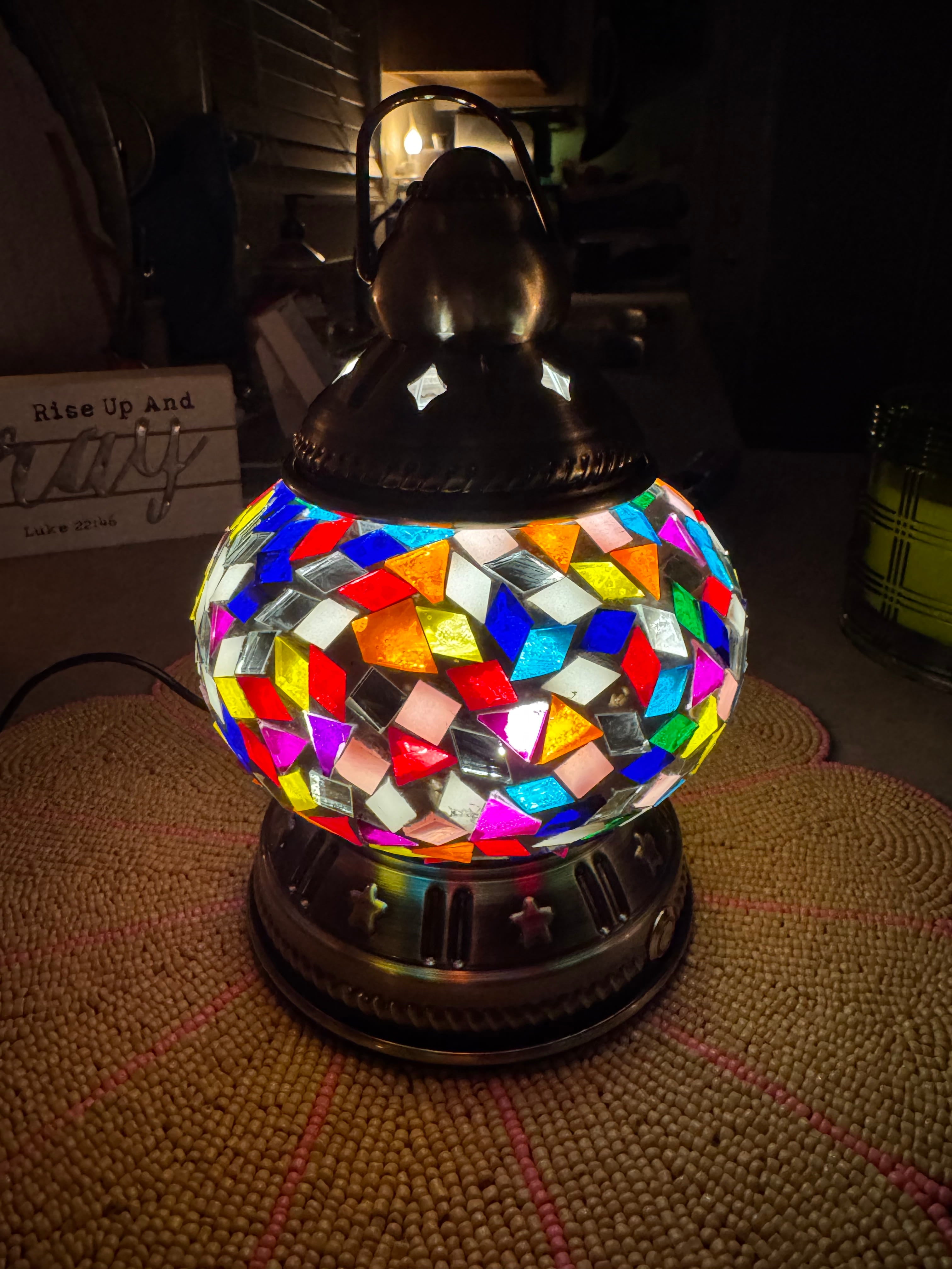 Colorful mosaic rechargeable lamp on a textured surface with a dark background