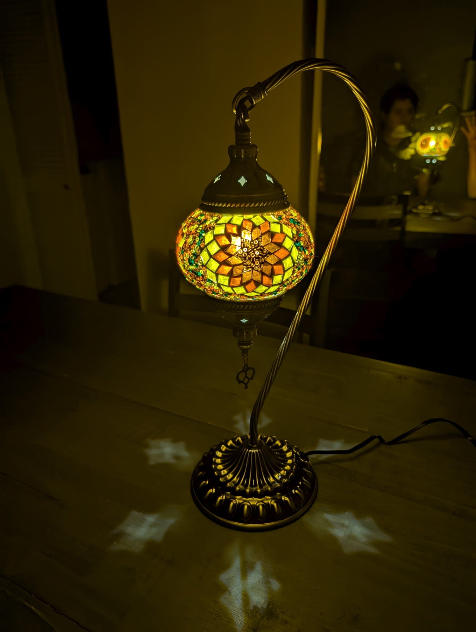 Stained glass swan lamp on a table with a dark background