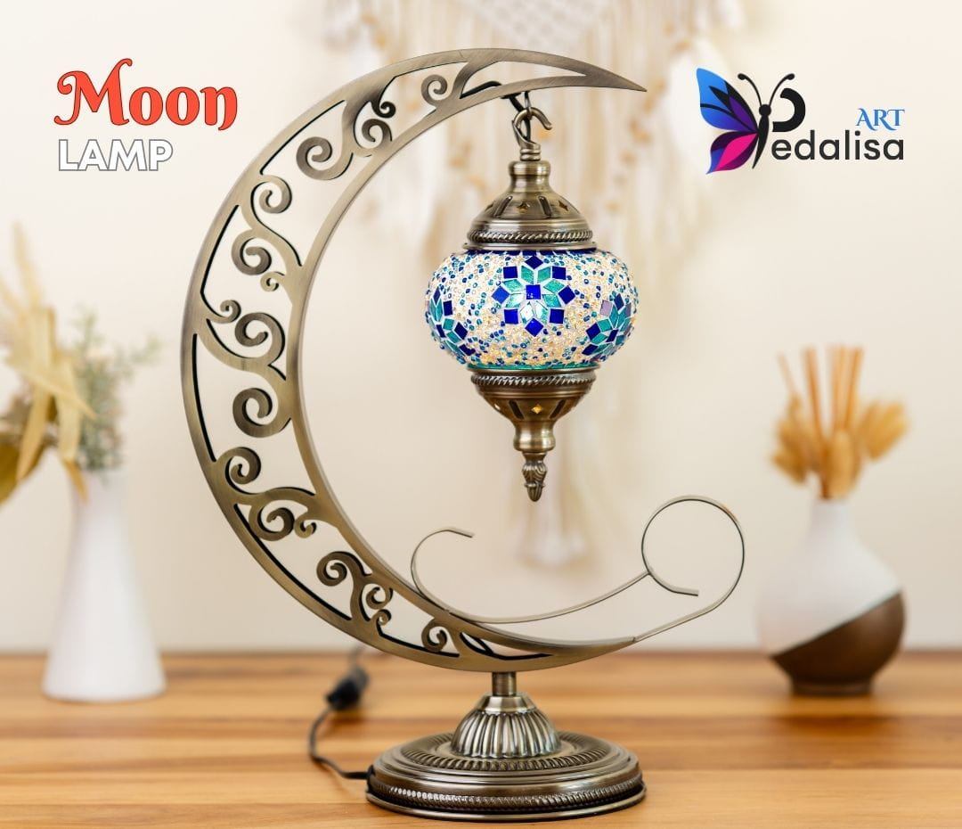 Decorative moon-shaped lamp with mosaic design on a wooden surface