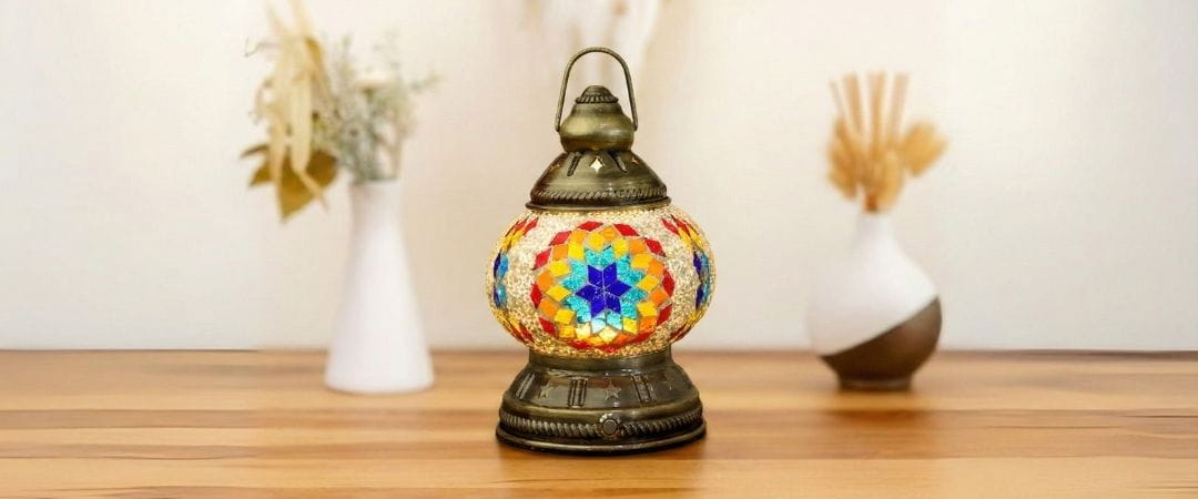 Decorative lantern with colorful mosaic design on a wooden surface.