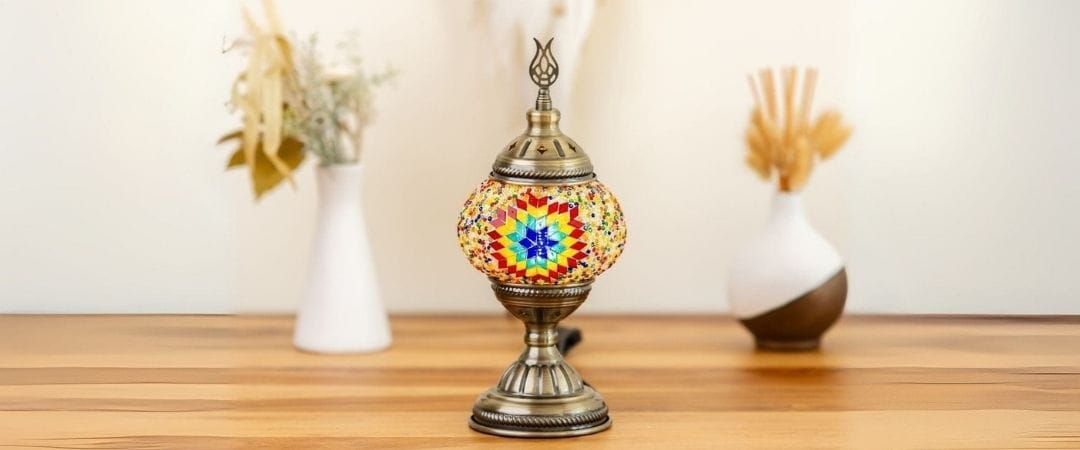 Decorative mosaic table lamp with colorful design on a wooden surface