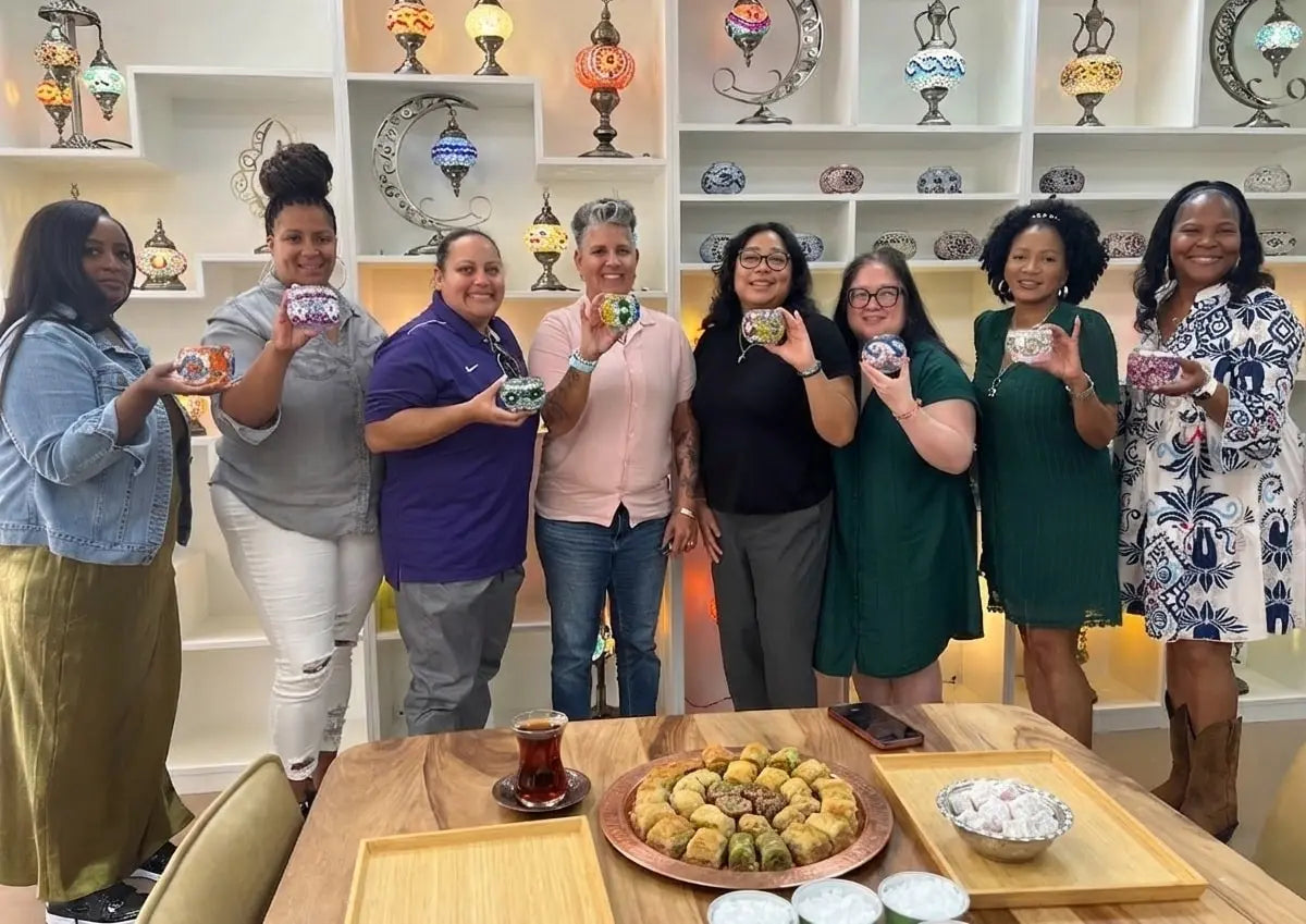 Houston corporate team relaxing and connecting during a creative mosaic lamp making workshop at Pedalisa Art studio.