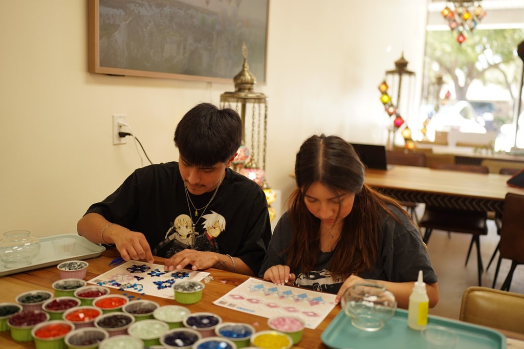 A happy couple enjoying a creative at-home date night making DIY Turkish mosaic lamps together.