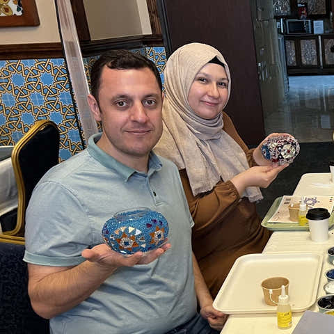 Two people holding decorative Turkish mosaic Lamp  in a casual setting