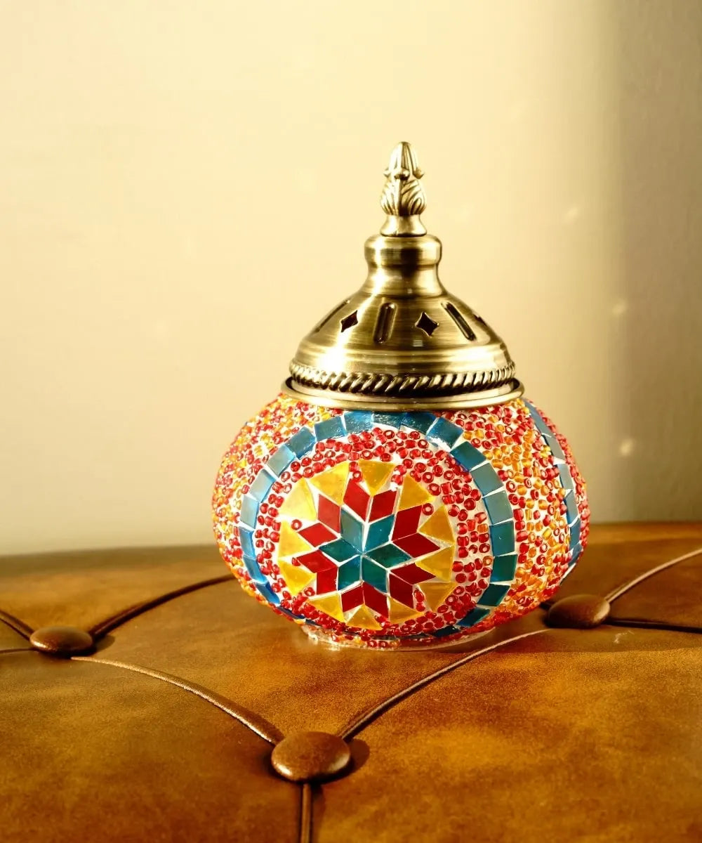 Decorative lamp with mosaic design on a wooden surface