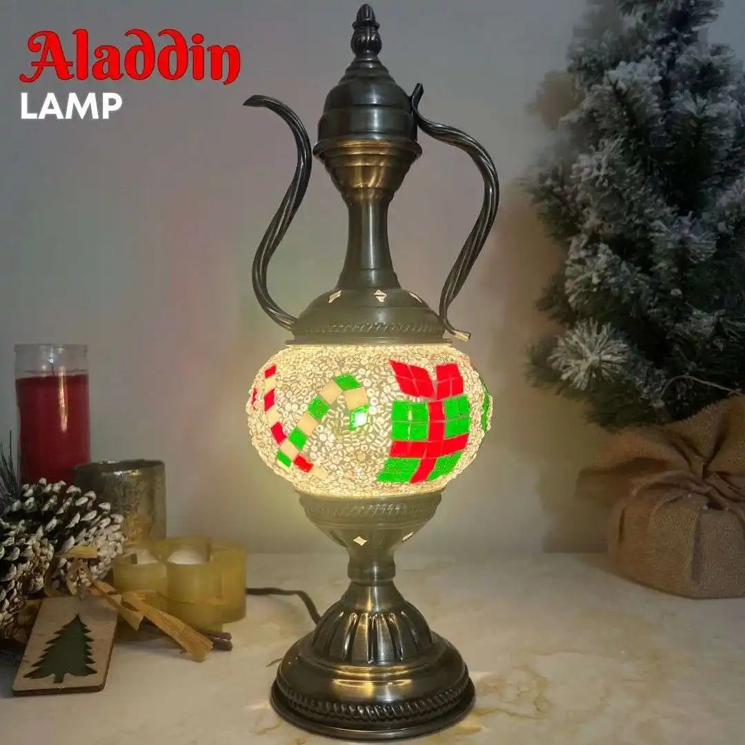 Decorative lamp with 'Aladdin' branding on a table with candles and a Christmas tree.