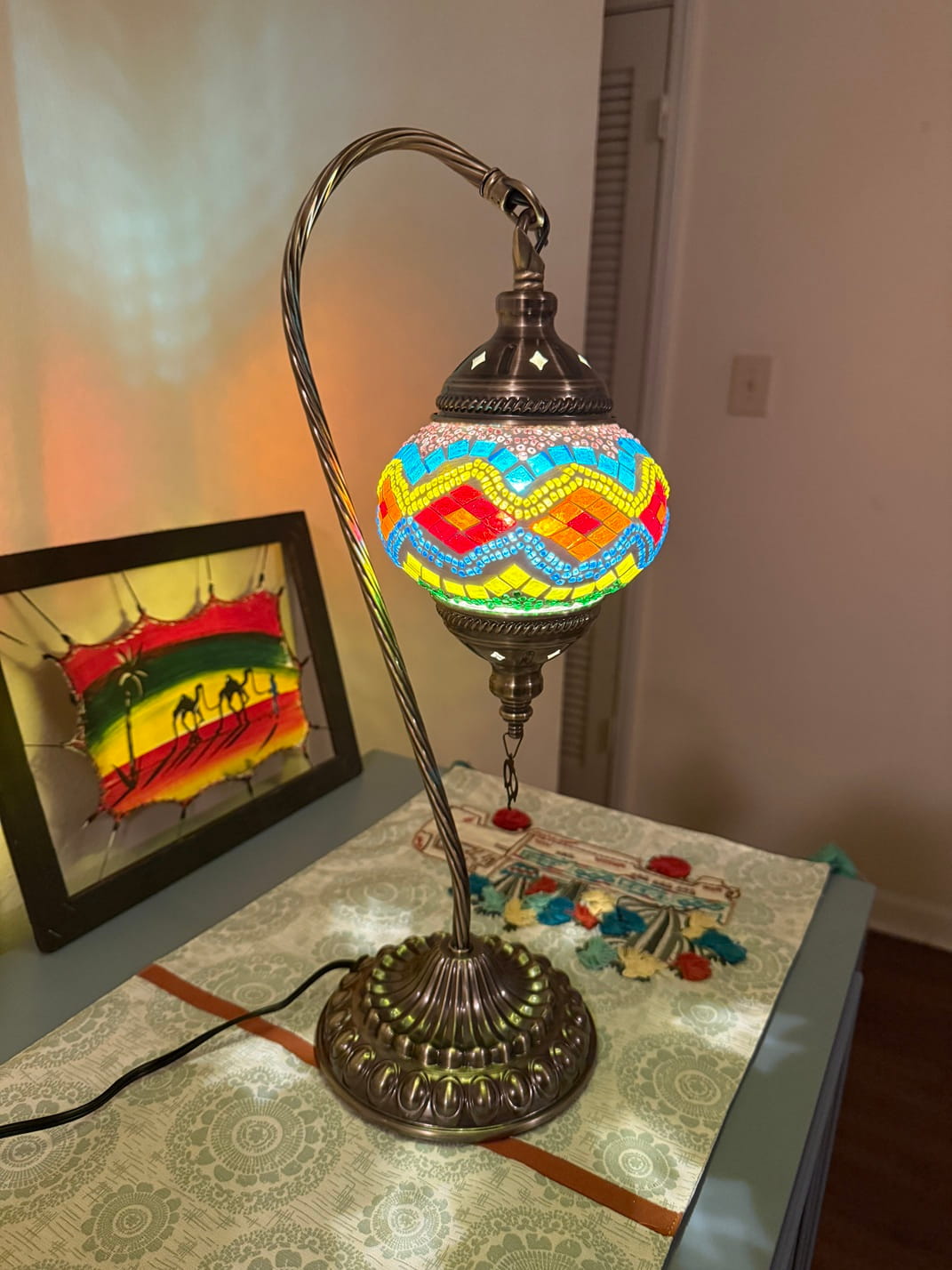 Decorative swan lamp with colorful glass shade on a table