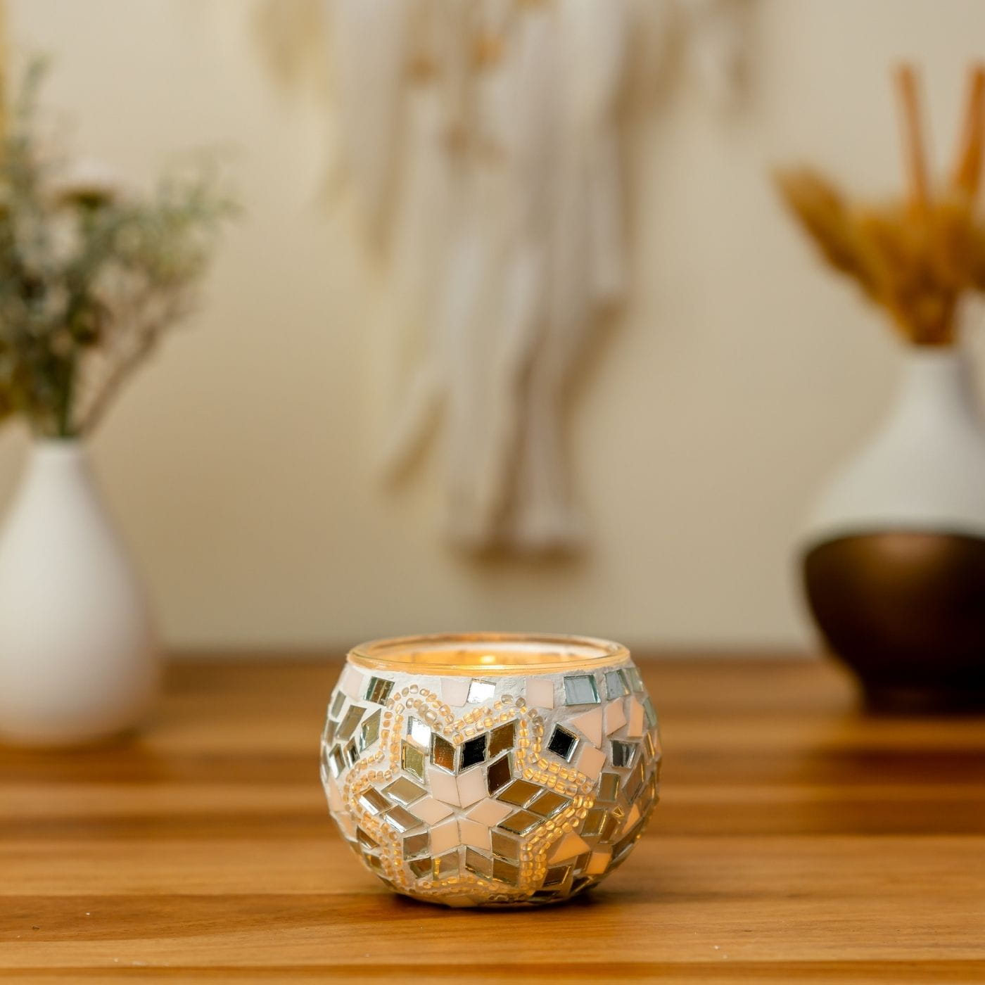 Decorative candle holder on a wooden surface with blurred background