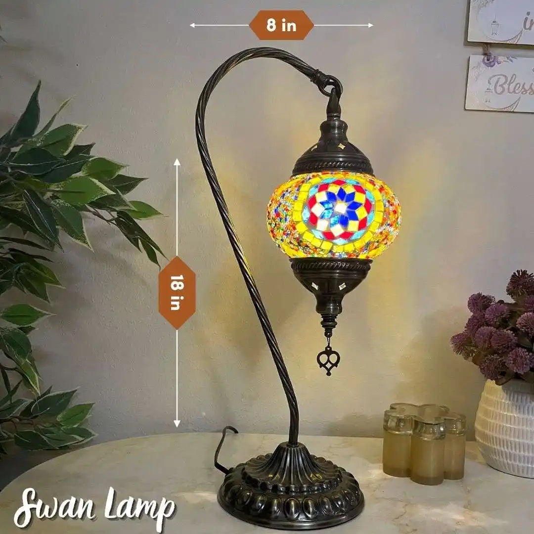 Turkish Moroccan mosaic Swan lamp with colorful mosaic shade on a table next to a plant and decorative items.