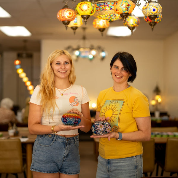 Friends celebrating at a Turkish mosaic lamp workshop in Houston