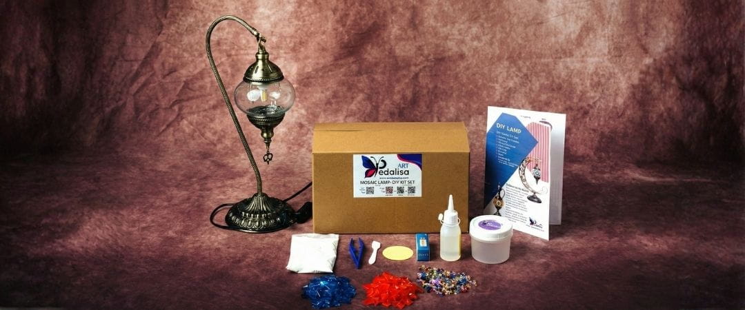 DIY kit with mosaic materials and a lamp on a brown background