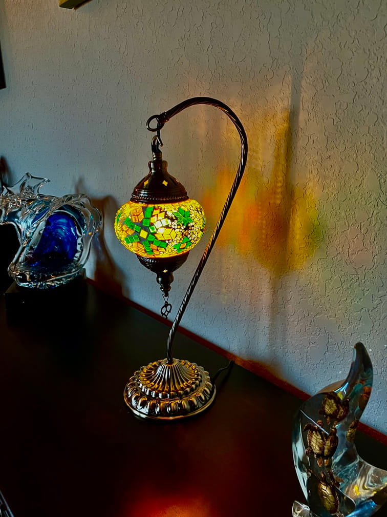 Decorative swan lamp with colorful mosaic design on a dark surface.