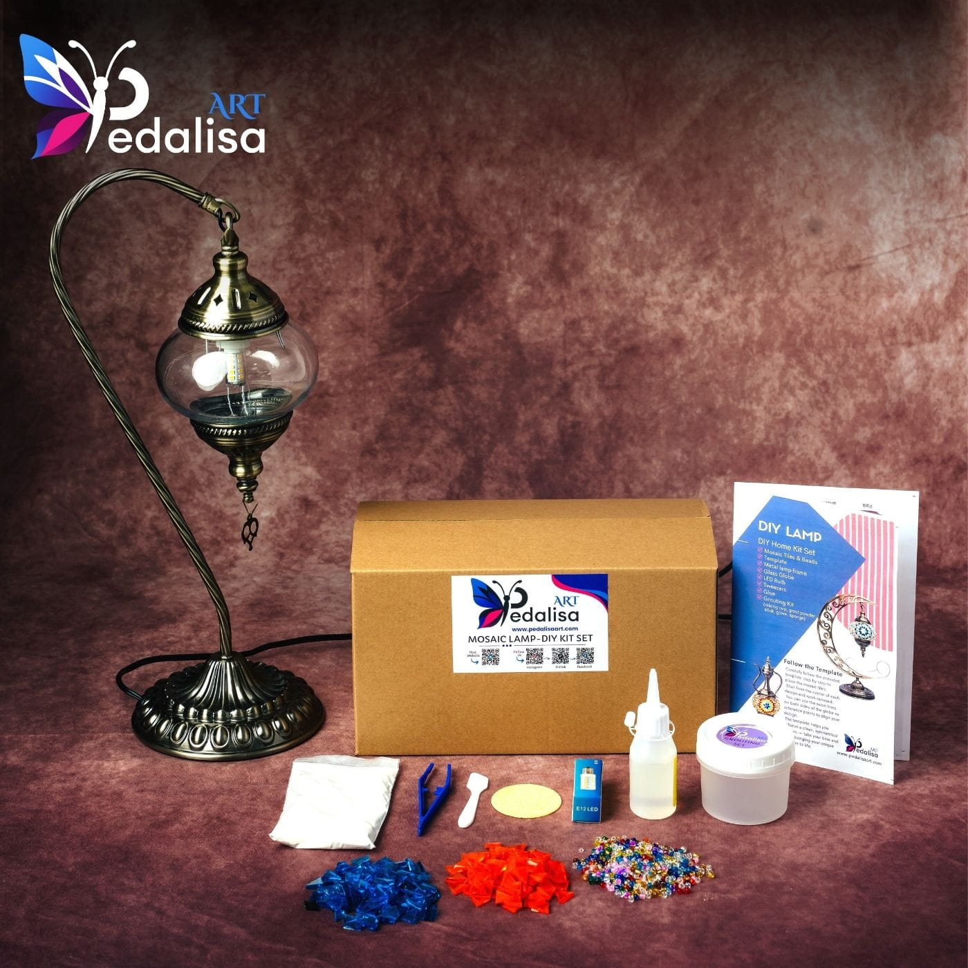 Pedalisa mosaic swan lamp-making kit with materials on a brown background