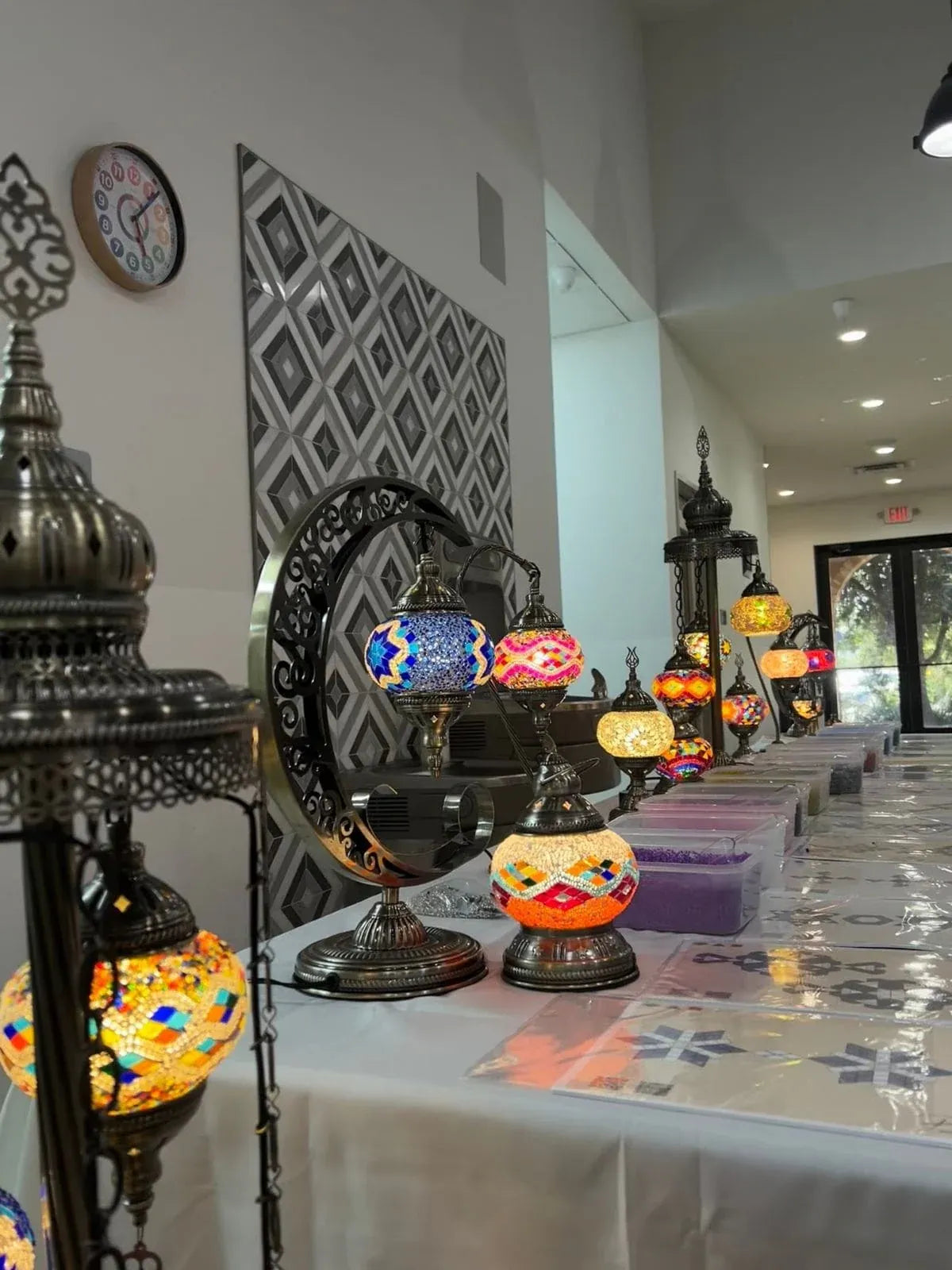 Decorative lamps on a table with a patterned wall in the background